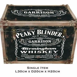 May include: A black wooden storage box with a distressed finish. The box features a vintage-style label with the text "Peaky Blinders Old Time The Garrison Shelby Bro's Birmingham Whiskey 70cl 40% Vol Distilled and Bottled by Shelby Company Ltd". The box measures 30 inches long, 20 inches deep, and 20 inches high.