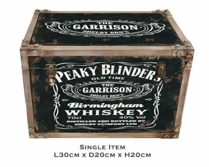 May include: A black wooden storage box with a distressed finish. The box features a vintage-style label with the text "Peaky Blinders Old Time The Garrison Shelby Bro's Birmingham Whiskey 70cl 40% Vol Distilled and Bottled by Shelby Company Ltd". The box measures 30 inches long, 20 inches deep, and 20 inches high.