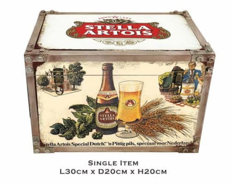 May include: A wooden storage box with a vintage design featuring a Stella Artois beer bottle and glass. The box has a brown wooden frame with metal accents and a cream-colored background. The box is 12 inches long, 8 inches wide, and 8 inches high. "Stella Artois Special Dutch" 'n Pittig pils, speciaal voor Nederland is printed on the box.