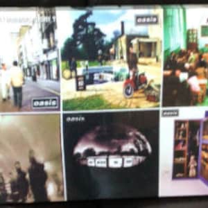 May include: A collection of 10 Oasis album covers. The covers feature a variety of images, including a cityscape, a band performing, and a group of people standing in front of a building. The album titles are visible on the covers, including "Definitely Maybe", "(What's the Story) Morning Glory?", "Be Here Now", and "Standing on the Shoulder of Giants".