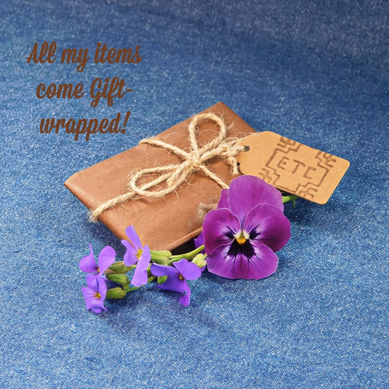 Gift wrapped item in brown tissue paper with hemp string and and hand stamped gift tag with ETC logo. On a blue denim background with Pansy & Aubretia Flowers. With the words All my Items come Gift Wrapped!