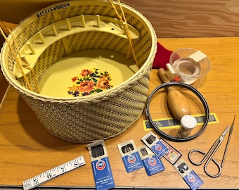 May include: A vintage wicker sewing basket with a floral design and a yellow interior. The basket is filled with sewing supplies, including needles, thread, and a pair of scissors. The basket is labeled "Harvey".
