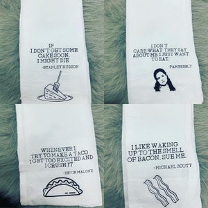 May include: Four white kitchen towels with black text and illustrations. The towels feature quotes from the TV show "The Office". The quotes are: "If I don't get some cake soon, I might die. -Stanley Hudson", "I don't care what they say about me. I just want to eat. -Pam Beesly", "Whenever I try to make a taco I get too excited and I crush it. -Kevin Malone", and "I like waking up to the smell of bacon, sue me. -Michael Scott".