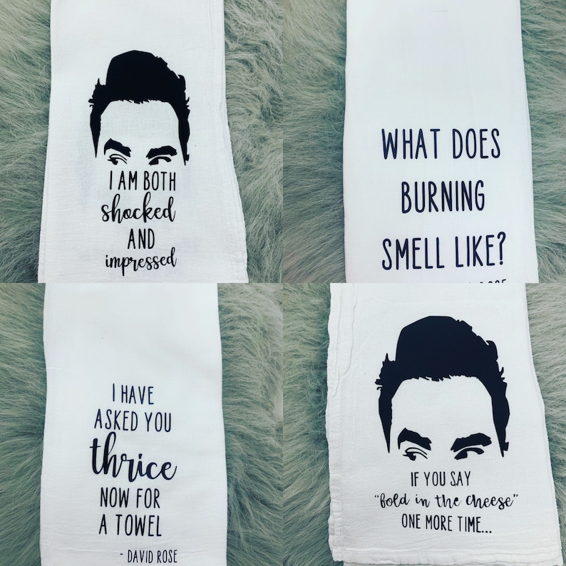 May include: Four white kitchen towels with black text and a black silhouette of a man's face. The text on the towels reads: "I am both shocked and impressed", "What does burning smell like?", "I have asked you thrice now for a towel - David Rose", and "If you say "fold in the cheese" one more time..."