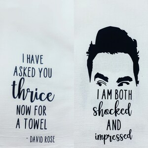 May include: A white kitchen towel with black text that reads "I have asked you thrice now for a towel - David Rose" and a black silhouette of a man's face with the text "I am both shocked and impressed".