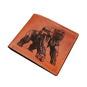 以下が含まれることがあります： ゴリラの白黒の彫刻が施された茶色の革財布