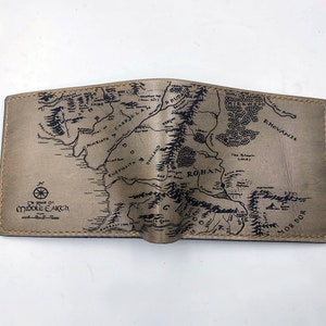 May include: A brown leather wallet with a map of Middle-earth printed on the front. The map includes the text "The realms of Middle-earth".
