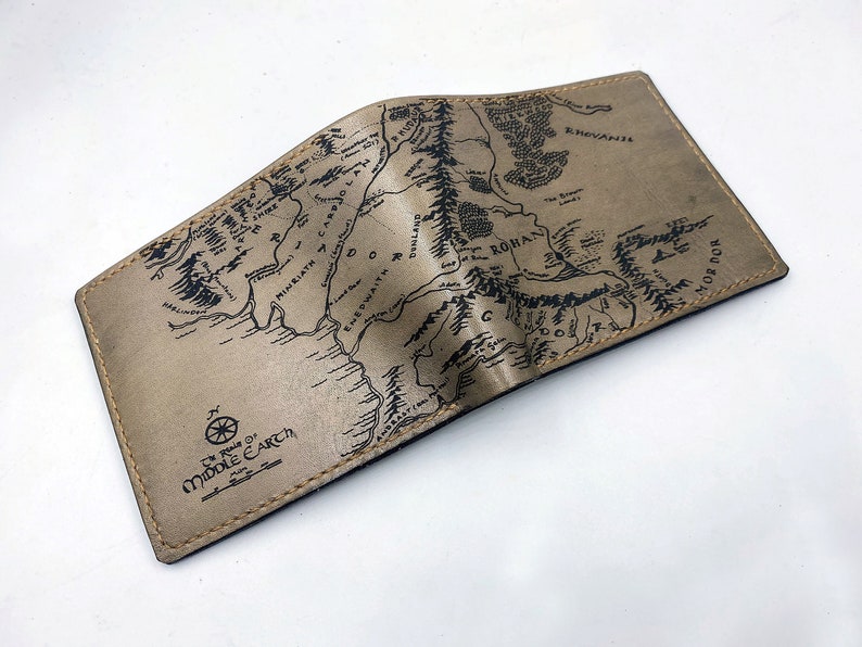 May include: A brown leather wallet with a map of Middle-earth printed on the front. The map includes the text "The Realms of Middle-earth".