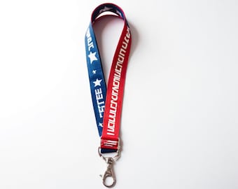May include: A red and blue lanyard with white stars and the text "I WILL VOTE AND MAKE A DIFFERENCE" on one side and "REGISTER TO VOTE" on the other side. The lanyard has a silver clip.