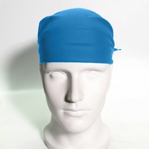 May include: A solid blue bandana tied around a mannequin's head. The bandana is made of a soft, smooth fabric.