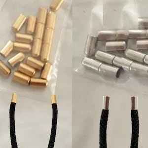 Puede incluir: Dos juegos de terminales de cordón, uno dorado y otro plateado, con cordones negros unidos. Los terminales de cordón son pequeños tubos metálicos.