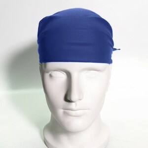 May include: A solid blue bandana made of a soft, stretchy fabric. The bandana is tied around a mannequin's head.