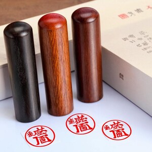 Peut inclure: Trois tampons en bois avec des tampons d'encre rouges. Les tampons sont noirs, bruns et rouges. Les tampons d'encre portent des caract&egrave;res chinois en rouge.