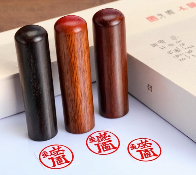 Peut inclure: Trois tampons en bois avec des tampons d'encre rouges. Les tampons sont noirs, bruns et rouges. Les tampons d'encre portent des caract&egrave;res chinois en rouge.