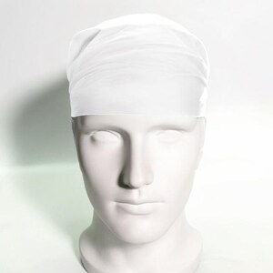 May include: White surgical cap made of a thin, breathable fabric. The cap is designed to cover the hair and keep it out of the way during medical procedures.