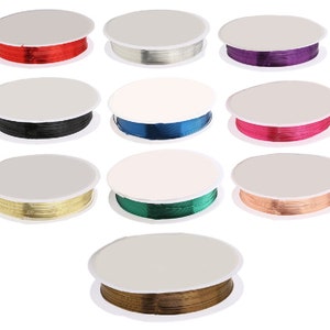 Può includere: Assortimento di dieci bobine di filo colorato, ciascuna avvolta attorno a una bobina di plastica bianca. I colori includono rosso, argento, viola, nero, blu, rosa, oro, verde, rame e marrone.