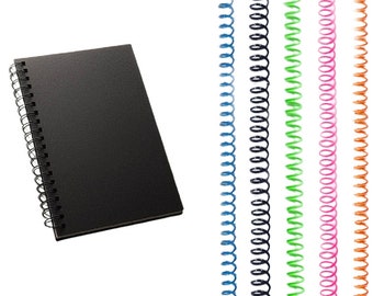 Puede incluir: Cuaderno negro de espiral con una cubierta negra. El cuaderno está al lado de un conjunto de seis espiras de encuadernación de metal de diferentes colores. Los colores son azul, negro, verde, rosa y naranja.