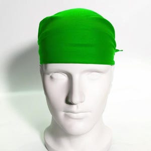 May include: A bright green bandana made of a soft, smooth fabric. The bandana is folded and tied around a mannequin's head.