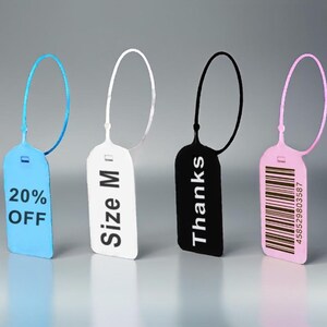 Op de afbeelding: Vier verschillende gekleurde plastic labels met touwtjes. De labels zijn rechthoekig en hebben verschillende tekst erop gedrukt. De tekst op de labels luidt "20% OFF", "Maat M", "Bedankt" en een barcode met het nummer "458529803587".