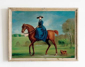 May include: A framed oil painting depicting a woman in a blue dress and a black hat riding a brown horse. The woman is riding side-saddle and the horse is walking through a grassy field. A small brown dog is walking behind the horse.