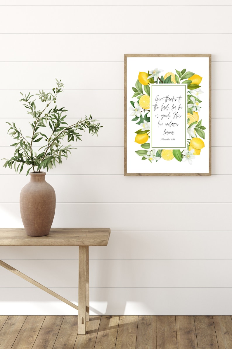 May include: A framed print with a white background and a lemon wreath border. The print features the text "Give thanks to the Lord, for he is good; his love endures forever. 1 Chronicles 16:34".