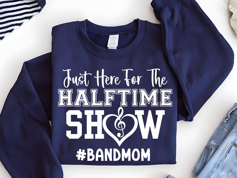 May include: Navy blue sweatshirt with the text "Just Here For The Halftime Show" in white. The word "SHOW" is inside a heart with a treble clef. Below the heart is the hashtag "#BANDMOM".