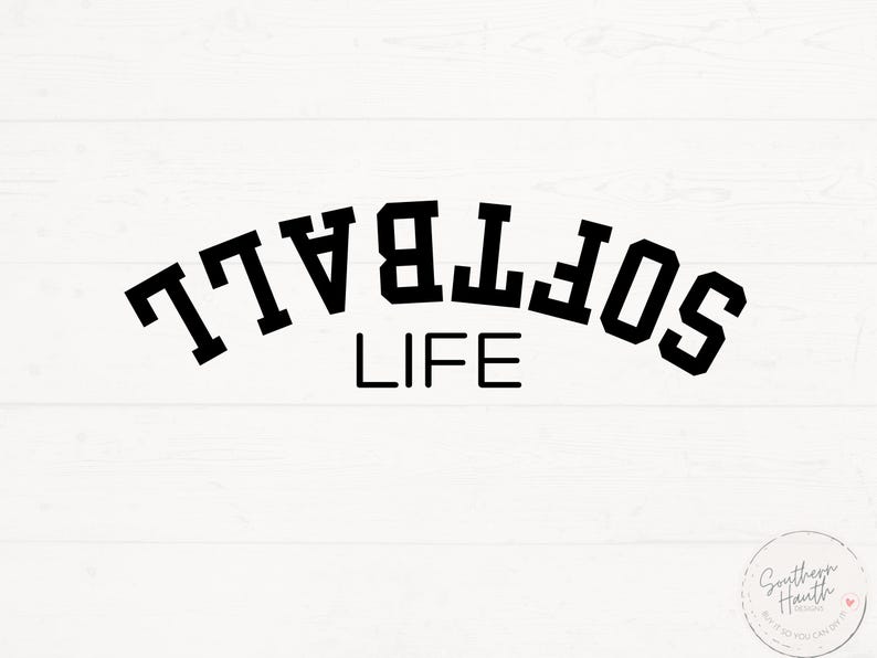 May include: A white wooden background with the words "SOFTBALL LIFE" in bold, black, block letters. The word "SOFTBALL" is arched above the word "LIFE". A small circular logo is in the bottom right corner.
