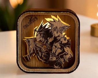 May include: A wooden Final Fantasy VII themed night light. The light features a square frame with a detailed laser-cut design of two characters. The light is illuminated from within, creating a warm glow. The text "FINAL FANTASY VII" is visible on the top left corner.
