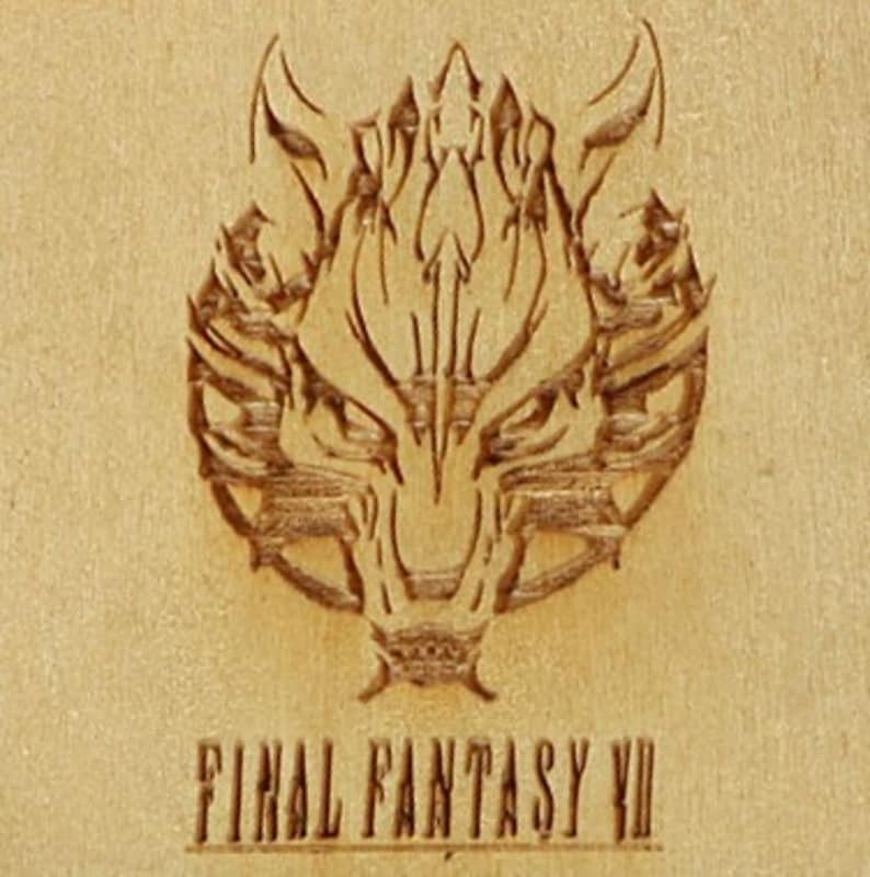 May include: A wooden carving featuring the wolf emblem from Final Fantasy VII. The emblem is intricately detailed, with sharp lines and a textured appearance. The text "FINAL FANTASY VII" is carved below the emblem.