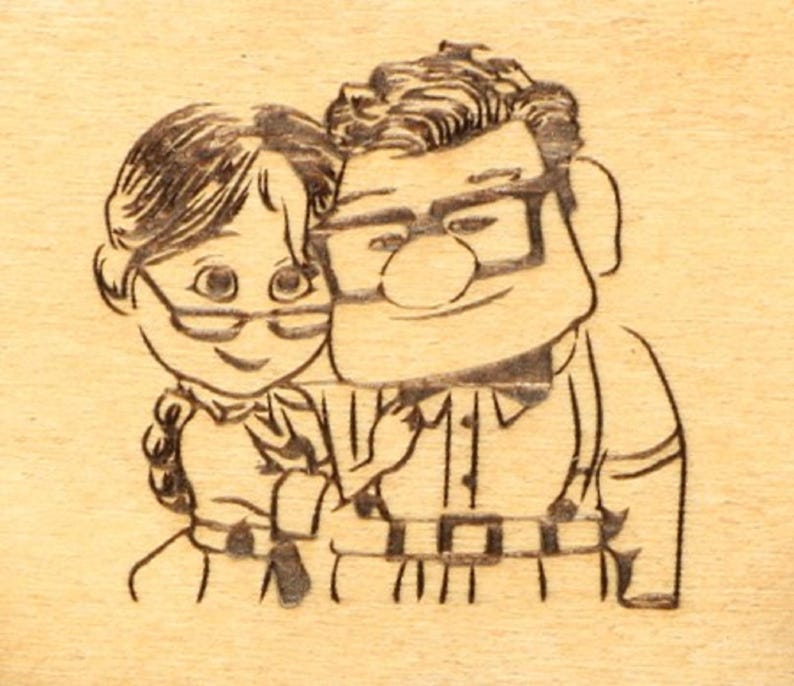May include: A wood-burned image of a cartoon couple, both wearing glasses and smiling. The man has thick-rimmed glasses and a button-down shirt. The woman has a braided hairstyle. The image is on a light-colored wooden surface.