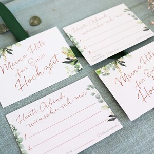 May include: Four white cards with green floral designs and copper calligraphy. The cards have the text "Meine Hits fur Eure Hochzeit" and "Heute Abend wunsche ich mir".
