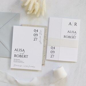 May include: A white wedding invitation with the names Alisa and Robert, the date 04.09.27, and the text "Save the Date".