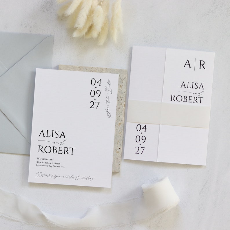 May include: A white wedding invitation with the names Alisa and Robert, the date 04.09.27, and the text "Save the Date".