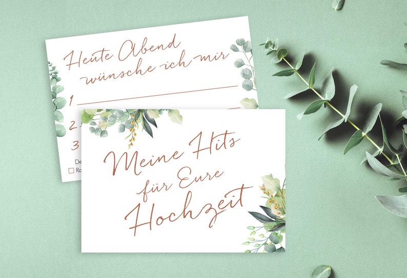 May include: Two white cards with a floral design. The top card has the text "Heute Abend w&uuml;nsche ich mir" and numbered lines for writing. The bottom card has the text "Meine Hits f&uuml;r Eure Hochzeit".