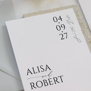May include: Save the Date card with the date 04.09.27 and the names Alisa and Robert.