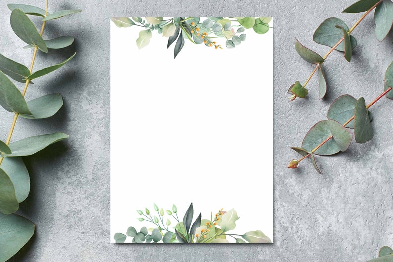 K&ouml;nnte beinhalten: Eine leere wei&szlig;e Karte mit einem Aquarellrand aus gr&uuml;nen Bl&auml;ttern und Blumen. Die Karte ist von Eukalyptuszweigen auf einem grauen Hintergrund umgeben.