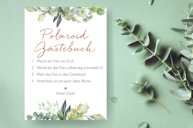Peut inclure: Une carte blanche avec des bordures florales vertes et le texte "Polaroid G&auml;stebuch" en lettres brunes. La carte contient des instructions pour un livre d'or Polaroid&nbsp;: 1. Prenez une photo de vous, 2. Attendez que la photo se d&eacute;veloppe, 3. Collez la photo dans le livre d'or, 4. Laissez-nous quelques mots gentils. La carte se termine par "Vielen Dank!" en lettres brunes.