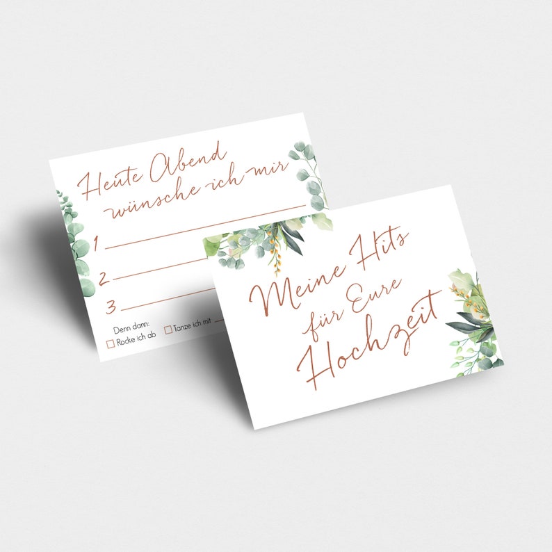 May include: Two white cards with green floral designs. The top card has the text "Heute Abend w&uuml;nsche ich mir" and numbered lines for writing. The bottom card has the text "Meine Hits f&uuml;r Eure Hochzeit".