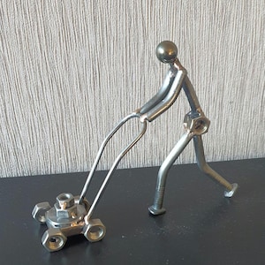 Gardener pushing a Lawnmower made from scrap metal