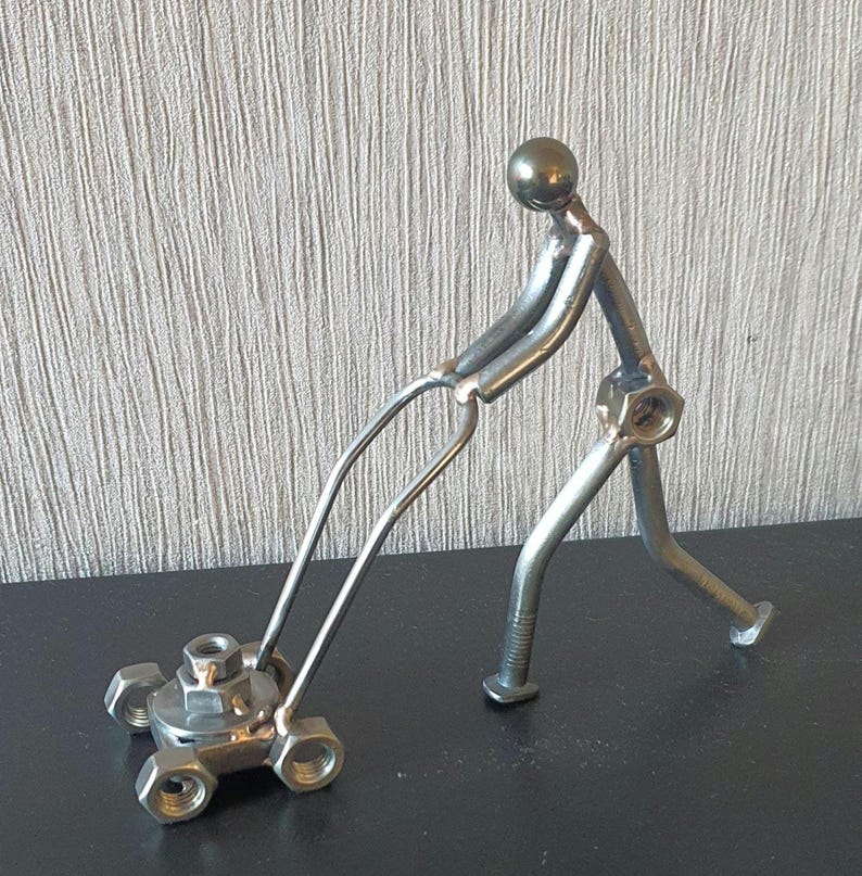 Gardener pushing a Lawnmower made from scrap metal
