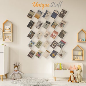 May include: A wall display of various books with colorful covers, arranged in a diagonal pattern. The text "Unique Stuff" is above the books. The room features white furniture, wooden shelves, and decorative toys.