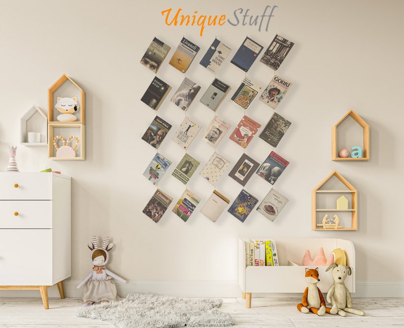 May include: A wall display of various books with colorful covers, arranged in a diagonal pattern. The text "Unique Stuff" is above the books. The room features white furniture, wooden shelves, and decorative toys.