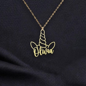 Puede incluir: Collar de oro con un colgante de unicornio con el nombre Olivia.