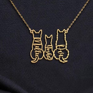 May include: A gold necklace with three cat silhouettes. The cats are facing forward and have the names 'Ollie', 'Joseph', and 'Ava' written on them.