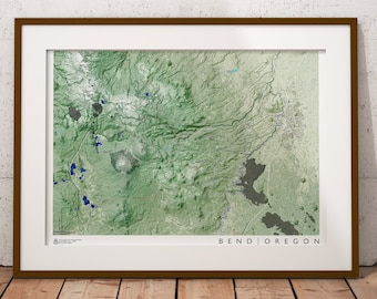 Puede incluir: Un mapa enmarcado de Bend, Oregón, con un esquema de color verde y azul. El mapa muestra el diseño de la ciudad y sus alrededores, incluidos lagos y ríos. El texto "Bend | Oregon" está impreso en la esquina inferior derecha del mapa.