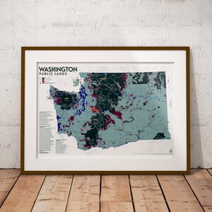 May include: A framed map of Washington state showing public lands. The map is color-coded to show different types of public lands, including national forests, national parks, and wildlife refuges. The map also includes a key that explains the different colors.