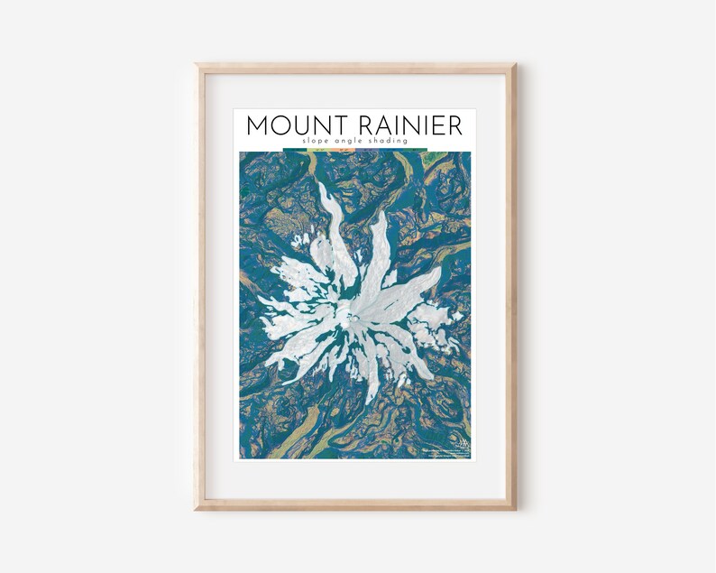 May include: A blue and white abstract illustration of Mount Rainier, a mountain in Washington state. The illustration uses slope angle shading to depict the mountain's topography. The text "MOUNT RAINIER" and "slope angle shading" is at the top of the image.