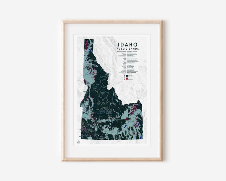 Puede incluir: Un mapa de Idaho que muestra las tierras p&uacute;blicas en diferentes colores. El mapa est&aacute; enmarcado en un marco de madera clara. El t&iacute;tulo del mapa es "Idaho Public Lands".