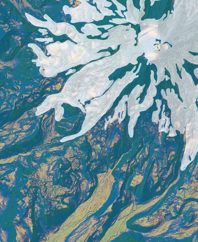 May include: An aerial view of a snow-capped mountain with a large crater at the top. The mountain is surrounded by green and blue terrain.