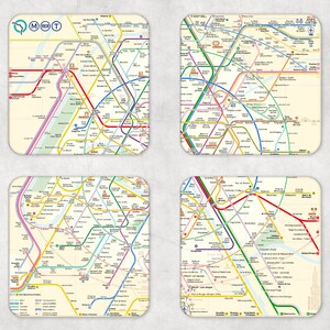May include: A set of four square coasters, each displaying a detailed map of the Paris Métro and RER train lines. The coasters show a network of colourful lines representing the different routes, with station names and landmarks. The coasters have a cream-coloured background.